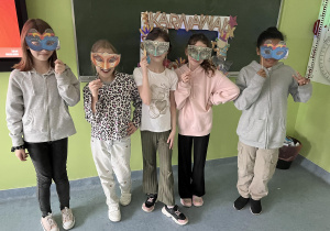 Grupa uczniów pozująca w maskach karnawałowych