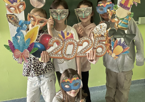 Grupa uczniów pozująca w maskach karnawałowych