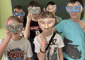 Grupa uczniów pozująca w maskach karnawałowych
