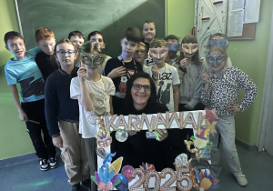 Uczniowie w maskach karnawałowych z Panią Dyrektor Anną Jagielską
