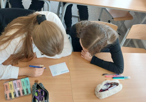 Uczniowie wypełniają pocztówki.