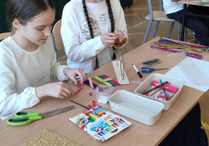 Dziewczynki tworzą model roweru z dostępnych materiałów