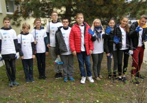 Klasa 8 c pozuje do zdjęcia pod sosną czarną.