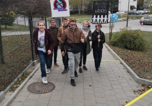 Grupa uczniów idzie z transparentami.
