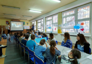 Uczestnicy debaty oglądają na dużym ekranie prezentację o prawach dziecka.