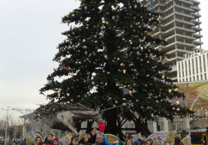 Dzieci z wychowawcą VId pod choinką przy ul. Piotrkowskiej.
