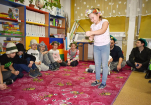 Uczniowie przyglądają się, jak ich koleżanka łowi na wędkę los z wróżbą.