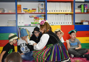 Chłopiec nakłuwa szpilką serce, na którym po drugiej stronie zapisane są imiona dziewcząt.
