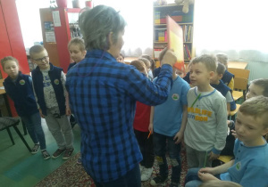 Nauczycielka pasuje uczniów na czytelników biblioteki.