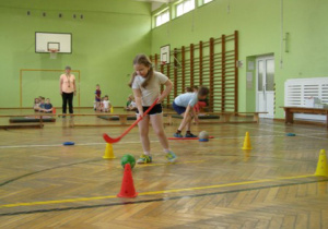 Przedszkolaki pokonują tor przeszkód na sali gimnastycznej.