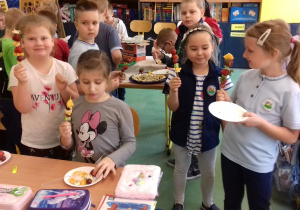 Dzieci przygotowują szaszłyki z warzyw i owoców.