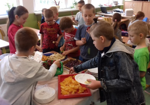 Chłopcy częstują się owocami.