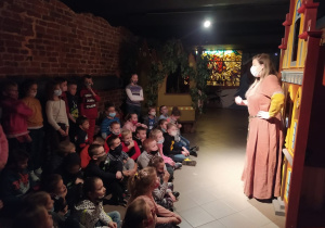 Dzieci siedzą na podłodze i słuchają legendy