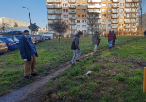 Chłopcy z klasy VIII b podczas zbierania śmieci z trawnika