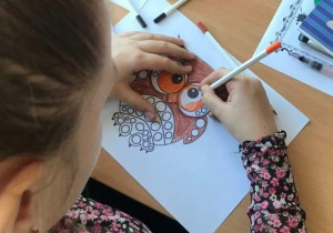 Dziewczynka, która wykonuje pracę plastyczną – sowę