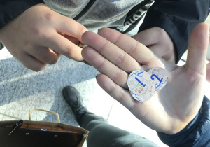 Na dłoni leżą 3 żetony-monety, które dzieci otrzymywały za poprawnie rozwiązane zadania.