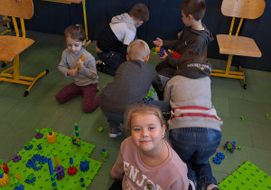 Dzieci budują z klocków.