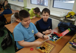 Dwóch chłopców czytających instrukcję do gry.