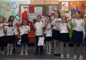 Grupa dzieci z chorągiewkami w dłoniach