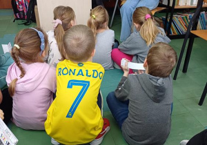 Uczestnicy świetlicy słuchają opowieści zimowej czytanej przez uczennice z klasy VI