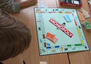 Uczniowie grają w grę "Monopoly".