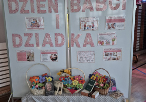 Napis Dzień Babci i Dziadka, kwiaty w koszach i książki polskich poetów