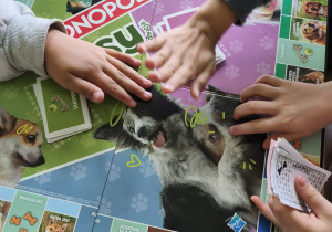 Uczniowie grają w grę Monopoly.