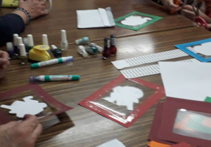 Uczniowie malują przyklejone szablony mazakami olejnymi.