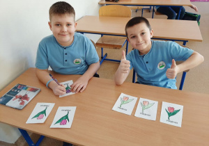 Uczniowie tworzą kartki z kwiatami w technice rysunkowej.