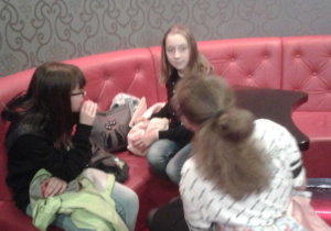 Dziewczynki siedzą na kanapach w oczekiwaniu na seans filmowy.