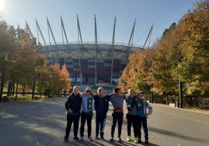 Grupa chłopców stoi na tle stadionu Narodowego.