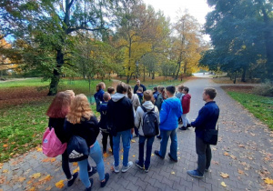 Grupa uczniów wraz z nauczycielem i przewodnikiem w Parku Źródliska
