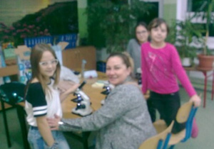 Mama z uczennicami przy mikroskopach.