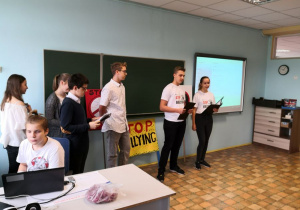 Grupa uczniów przedstawia prezentację w języku angielskim.