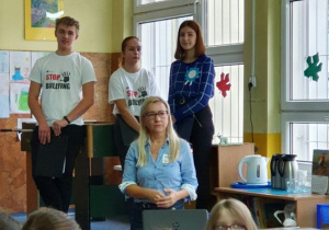 Koordynatorka działań Klubu Szkół Unicef wraz z członkami projektu Erasmus omawia prezentację w języku angielskim o przeciwdziałaniu przemocy w szkole. Uczniowie mają koszulki z napisem: Stop bullying.