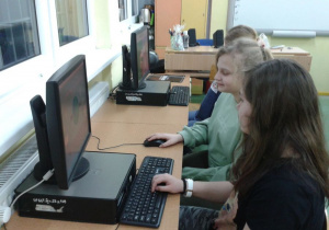 Uczniowie tworzą na komputerach prace konkursowe.