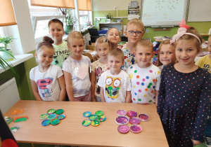 Grupa dzieci prezentująca pracę plastyczną z kół