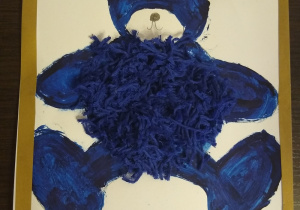 Niebieski miś namalowany farbami z brzuszkiem wyklejonym włóczką