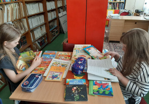 Dziewczynki przeglądają różne książeczki.