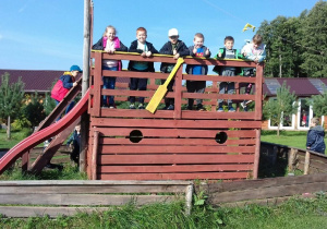 Dzieci stoją na górze zjeżdżali w kształcie łodzi