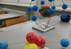 Modele atomu helu i magnezu wykonane z pokolorowanych kulek styropianowych