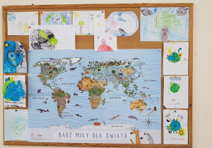 Prace plastyczne o tematyce ekologicznej i mapa z napisem: "Bądź miły dla świata".