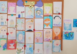 Galeria portretów nauczycieli i rysunki przedstawiające bukiety kwiatów.