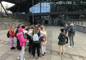 Uczniowie stoją przed wejściem dworca Łódź- Fabryczna.