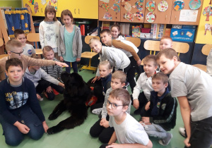 Grupa dzieci w towarzystwie psa.
