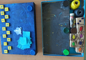 Gra planszowa niebieska "Śmieciobranie" z pionkami i kostka do gry wykonana przez uczniów klasy 5a