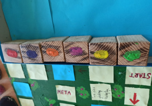 Gra planszowa niebieska "Śmieciobranie" z pionkami i kostka do gry wykonana przez uczniów klasy 5a