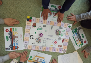 Gra planszowa "Segregujemy odpady" z pionkami i kostka do gry oraz karty wykonana przez uczniów klasy 4a