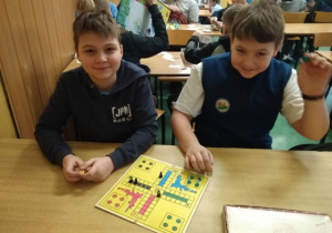 Dwóch chłopców gra w „Chińczyka”.