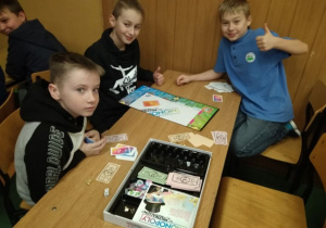 Trzech chłopców grających w „Monopoly”.